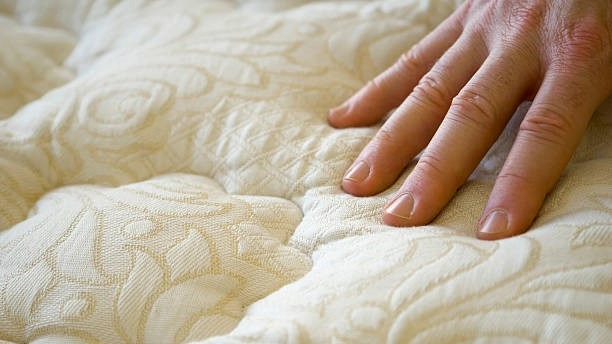 hand checking the mattress of wool